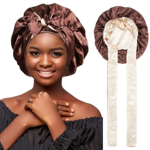 Detail of a brown and beige double-sided satin sleep bonnet with long adjustable straps