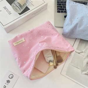 Detail of pink canvas makeup bag with silver stars showing interior storage for cosmetics