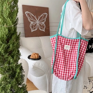 Red checkered canvas tote bag with turquoise trim shown in a lifestyle interior scene
