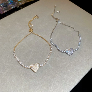 Detail of adjustable zircon heart bracelets in gold and silver finish with crystal pavé