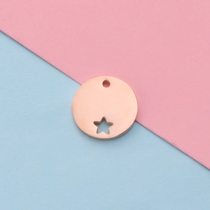 Macro view of rose gold round pendant with a hollow star cutout on a dual-tone background