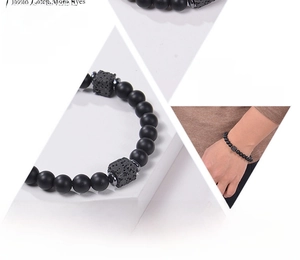 Close-up of black matte beads and volcanic rock bracelet with male model lifestyle view