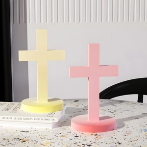 Detalle de cruces decorativas mate en rosa y amarillo pastel sobre una superficie moderna
