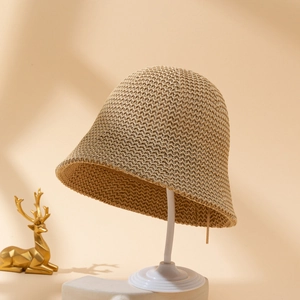 Elegante cappello a secchiello in paglia naturale su espositore per vacanze estive