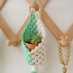 Handmade bohemian macrame plant hanger in beige and mint green with wooden ring