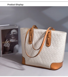 Detailed view of the large tote bag with beige hexagonal texture and brown leather trim