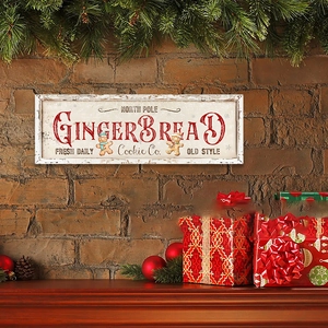 Retro Gingerbread Cookie Co. wooden Christmas sign hung on a red brick wall with holiday decor