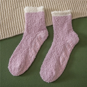Detailed view of purple fleece slipper socks featuring white fuzzy trim and anti-slip silicone grips