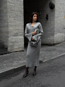 Detail of grey knitted two-piece set featuring V-neck cardigan and matching midi skirt