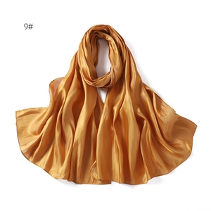 Close-up of champagne satin scarf showing smooth texture and pearlescent glossy finish