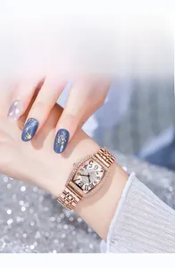 Gros plan d'une montre tonneau en or rose avec cristaux et bracelet en métal