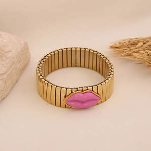 Detail of a gold-plated stretch bracelet featuring a pink enamel lip pendant decoration