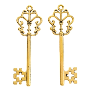 Detailed view of two vintage gold hollow crown key pendants for DIY jewelry making