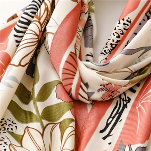 Detail of silk-feel scarf featuring coral floral patterns and exotic leopard print texture