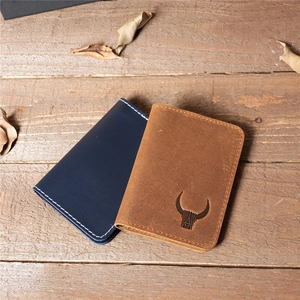 Retro crazy horse leather card holder in brown and navy on a rustic wood background