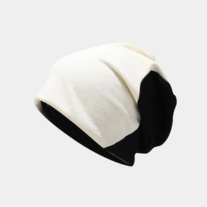 Detail showing high-elasticity knitted fabric texture on black and white beanie hat