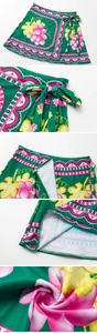 Detail of deep V-neck swimsuit wrap skirt with vintage grape floral patterns and waist bow