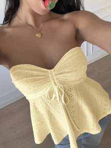 Close-up of yellow lace tube top featuring floral embroidery and drawstring tie