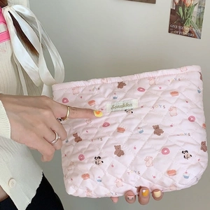 Pink quilted rabbit heart large cosmetic bag shown in model's hand for travel storage