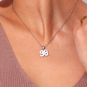 Close-up of a silver stainless steel necklace with a hollow number 98 pendant on a model
