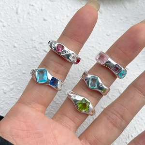Close-up of colorful heart and star zircon rings worn on fingers in Y2K style