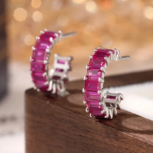 Detailed view of silver C-shape earrings with vibrant magenta rectangular cubic zirconia