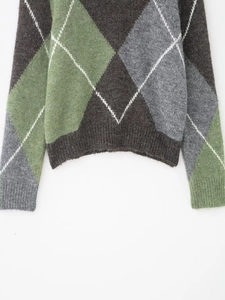 Détail du bord-côte et du motif à losanges sur un pull-over à col en V