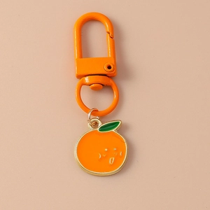 Detail of orange smiling fruit pendant and metal clip on a trendy fashion keychain