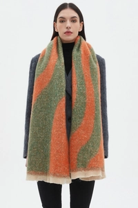 Detail showing wavy orange and green bouclé yarn pattern on soft winter scarf shawl