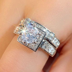 Close-up of double halo zircon ring set on hand with round-cut center stone on finger