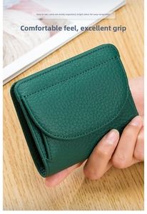 Dettaglio di un mini portafoglio in pelle martellata verde scuro con chiusura a patta