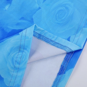 Dettaglio dell'orlo a doppio ago e della stampa floreale con rose blu sul vestito