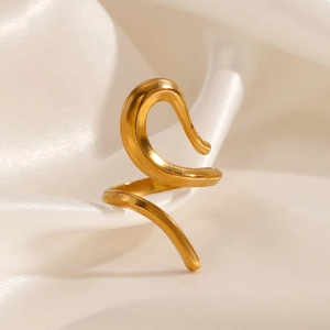 Polished gold plated stainless steel hollow geometric ring on cream silk background