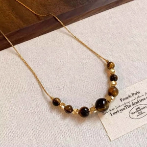 Detailed shot of tiger eye beads and golden metal spacers on a vintage beaded necklace
