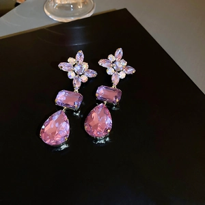Macro shot of purple teardrop crystal earrings with sparkling rhinestones and metal base