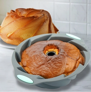 Detail of grey silicone cake mold with mint green handles and a freshly baked bundt cake