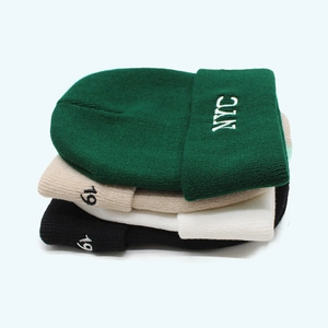 Detailed close-up of ribbed knitted beanies featuring NYC and 19 embroidery in four colors