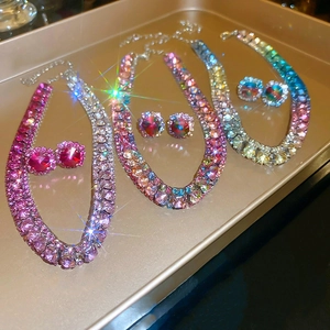 Detailed view of colorful rhinestone necklace and earring sets on a metal tray