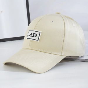 Classic beige baseball cap with AD patch on a white background, high-quality cotton fabric