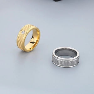 Close-up of gold and silver titanium rings with vertical texture and zircon inlay