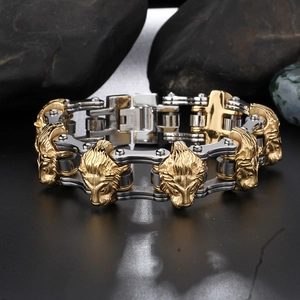 Detailed close-up of a two-tone stainless steel lion head biker chain bracelet on rock