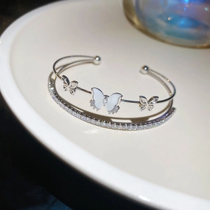 Detailed close-up of a silver double-layered cuff bracelet featuring zircon butterfly charms
