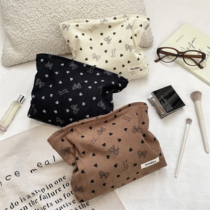 Detailed corduroy cosmetic bags in cream, black, and brown with sweet candy prints