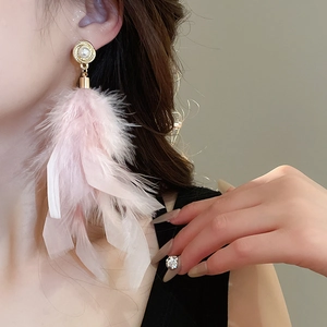 Detail view of long pink feather earrings with vintage gold studs and white pearls