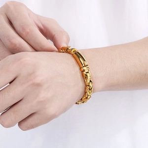 Close-up of men's chunky 18k gold-plated stainless steel chain bracelet on a male wrist