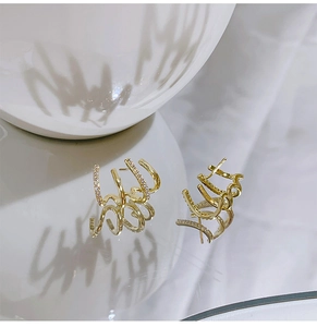 Detailed macro view of four-layer gold plated earrings with sparkling zircon inlay details
