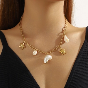 Bohemian gold-plated necklace featuring starfish, turtle, and shell charms on model