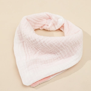 Detail of pink cotton muslin baby bib showing soft waffle texture and secure snap buttons