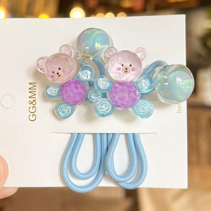 Détail d'élastiques à cheveux bleus avec breloques d'ours colorés et perles irisées