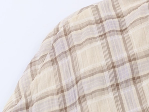Gros plan sur la texture du tissu écossais beige avec motif à carreaux brun et lavande